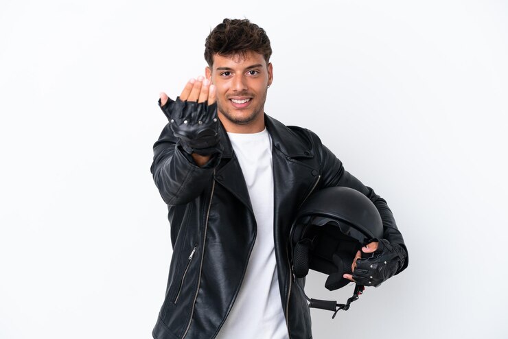 Foto jovem homem caucasiano com um capacete de motocicleta isolado no fundo branco, convidando para vir com a mão. feliz que você veio