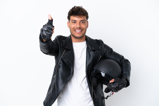 Jovem homem caucasiano com um capacete de motociclista isolado no fundo branco com o polegar para cima porque algo de bom aconteceu