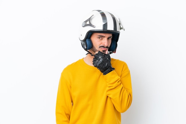 Jovem homem caucasiano com um capacete de motociclista isolado no fundo branco pensando