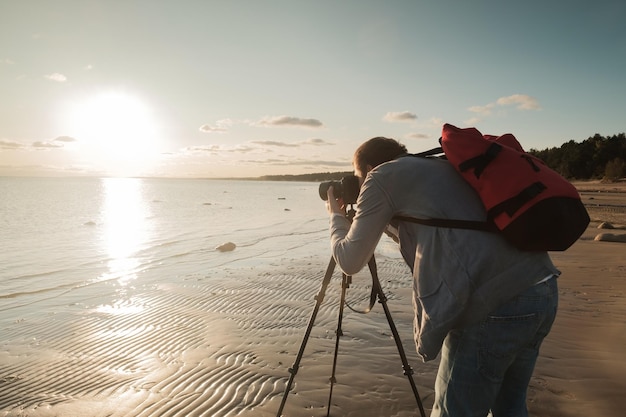 Jovem homem caucasiano fazendo foto da paisagem à beira-mar