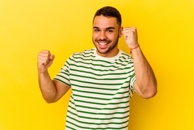 Foto jovem homem caucasiano isolado em um fundo amarelo, dançando e se divertindo.