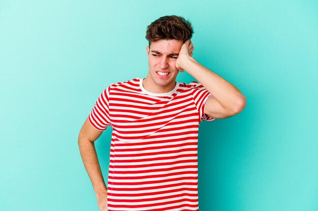 Jovem homem caucasiano isolado em um fundo azul, comemorando uma vitória, paixão e entusiasmo, expressão feliz.