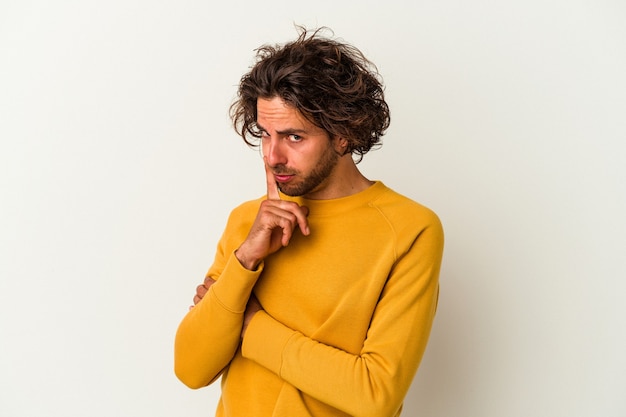 Jovem homem caucasiano isolado no fundo branco, contemplando, planejando uma estratégia, pensando na forma de um negócio.