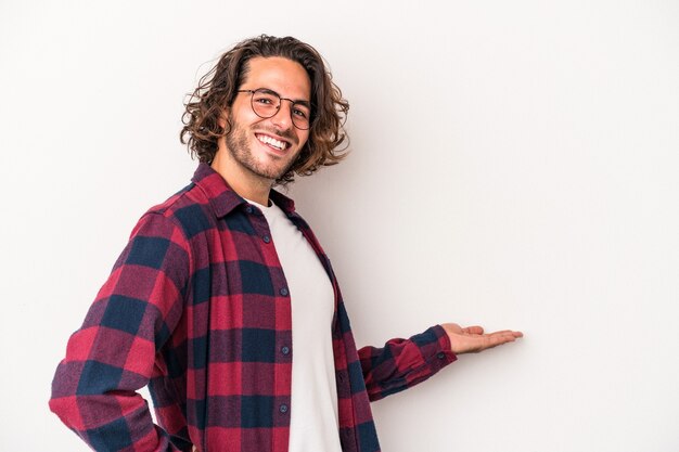 Jovem homem caucasiano isolado no fundo branco, mostrando uma expressão de boas-vindas.