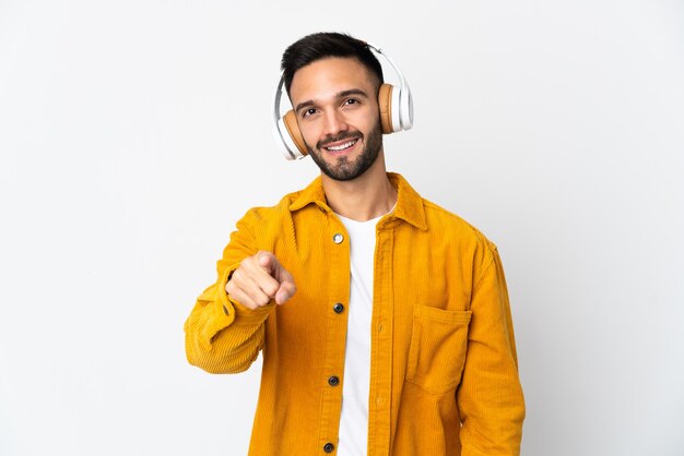 Jovem homem caucasiano isolado no fundo branco ouvindo música