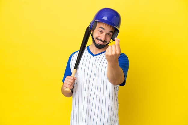 Jovem homem caucasiano jogando beisebol isolado em um fundo amarelo fazendo gesto de dinheiro