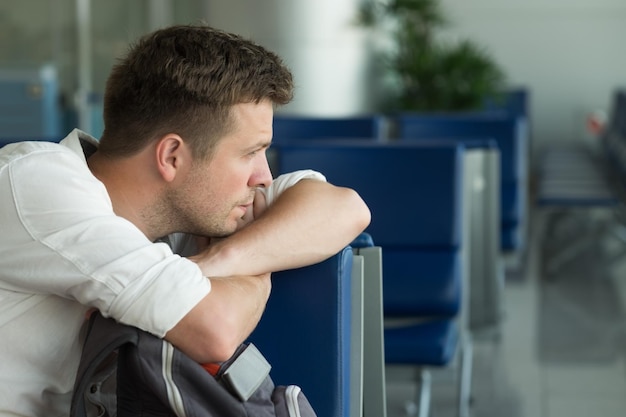 Foto jovem homem caucasiano no aeroporto esperando seu avião