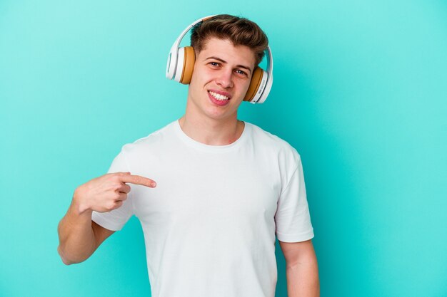 Jovem homem caucasiano ouvindo música com fones de ouvido isolados