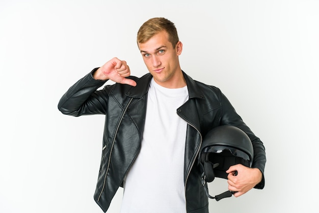 Jovem homem caucasiano segurando um capacete de moto isolado no fundo branco, de pé com a mão estendida, mostrando o sinal de pare, impedindo você.
