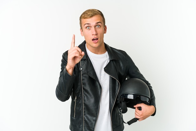 Jovem homem caucasiano segurando um capacete de moto isolado no fundo branco, tendo uma ideia, o conceito de inspiração.