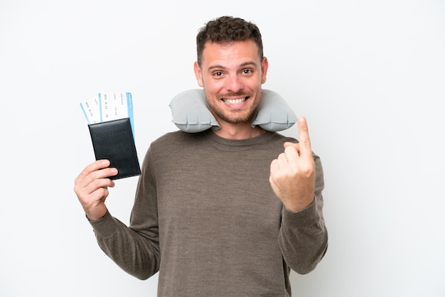 Jovem homem caucasiano segurando um passaporte isolado no fundo branco fazendo o gesto de vir