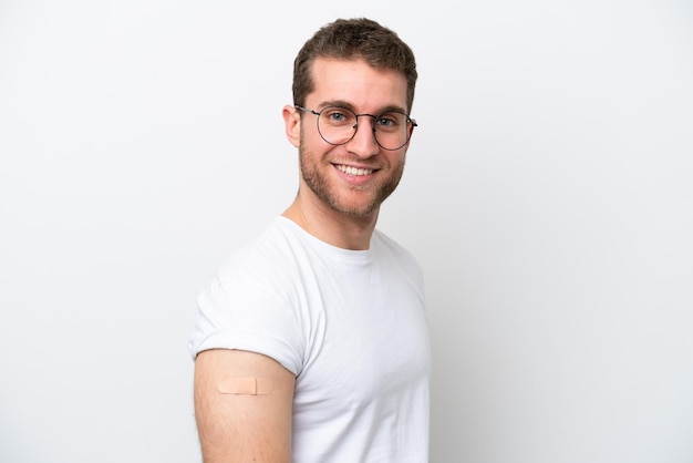 Jovem homem caucasiano usando band-aids isolado no fundo branco com expressão feliz