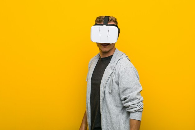Jovem homem caucasiano usando um óculos de realidade virtual