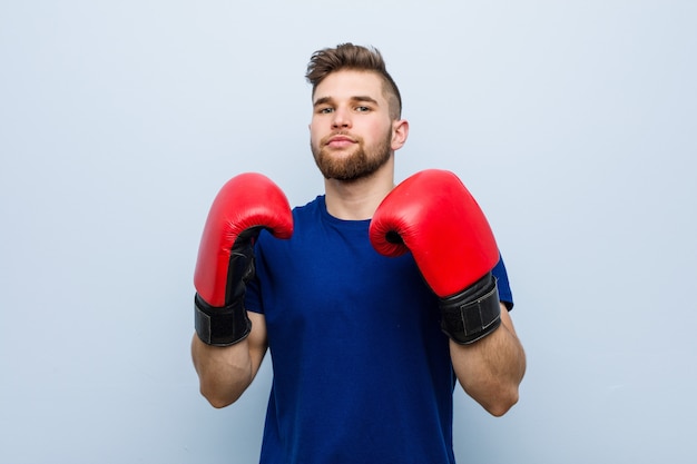 Jovem homem caucasiano vestindo uma luvas de boxe