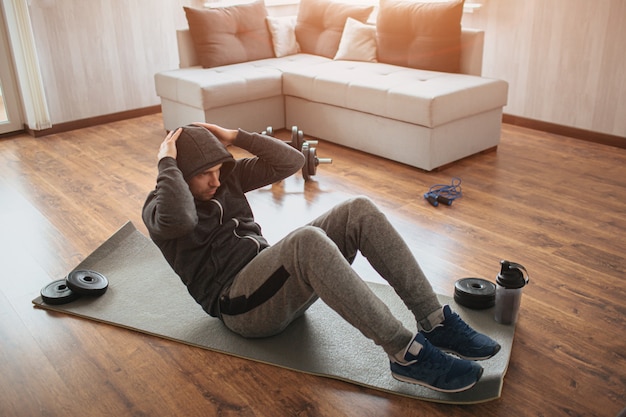 Jovem homem comum fazendo esporte em casa