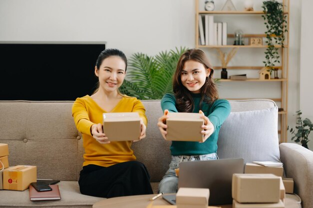 Foto jovem homem e mulher asiáticos no escritório de seu negócio compras on-line conceito de embalagem de marketing no escritório em casa