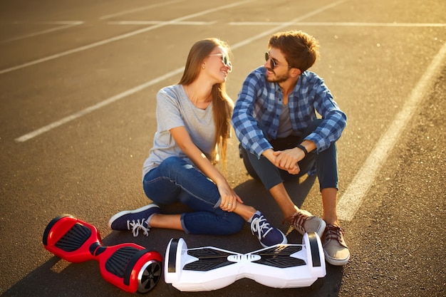 Jovem homem e mulher montando o hoverboard no parque tecnologias de conteúdo um novo movimento