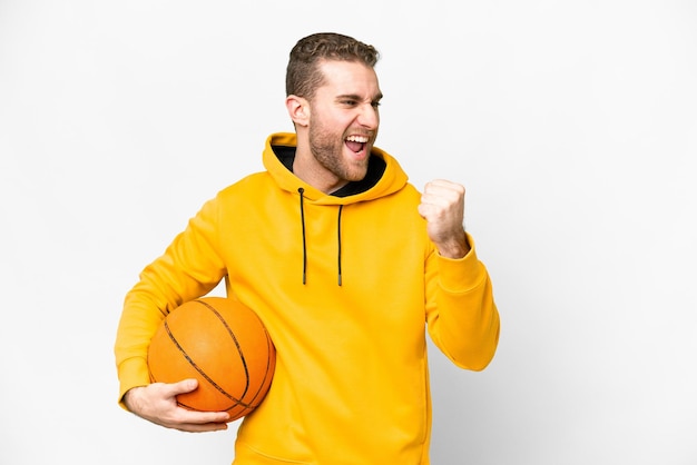 Jovem homem loiro bonito sobre fundo branco isolado, jogando basquete