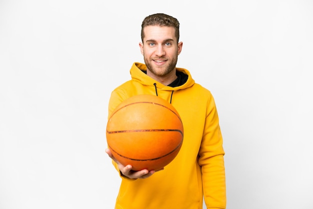 Jovem homem loiro bonito sobre fundo branco isolado, jogando basquete