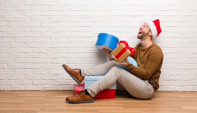 Jovem homem louco celebrando o Natal em sua casa