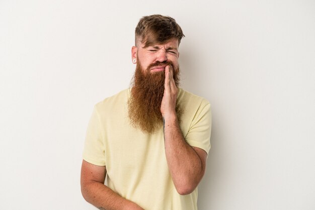 Jovem homem ruivo, caucasiano, com barba comprida, isolado no fundo branco, tendo uma forte dor nos dentes, dor molar.