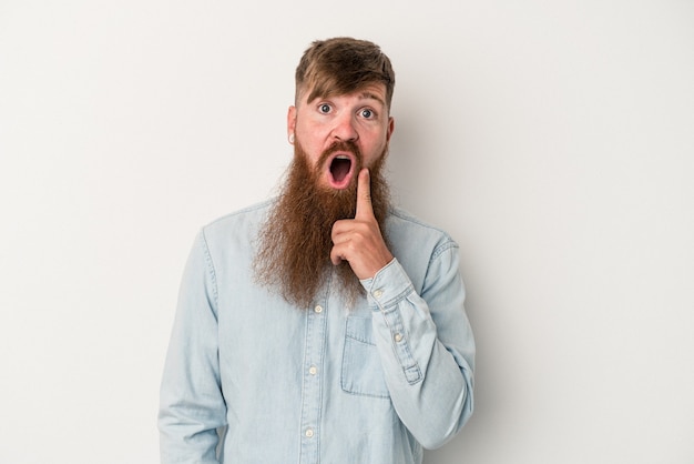 Jovem homem ruivo, caucasiano, com barba comprida, isolado no fundo branco, tendo uma ótima ideia, o conceito de criatividade.