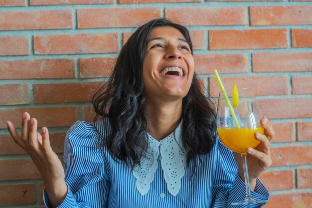 Foto jovem indiana a beber um sumo de laranja.