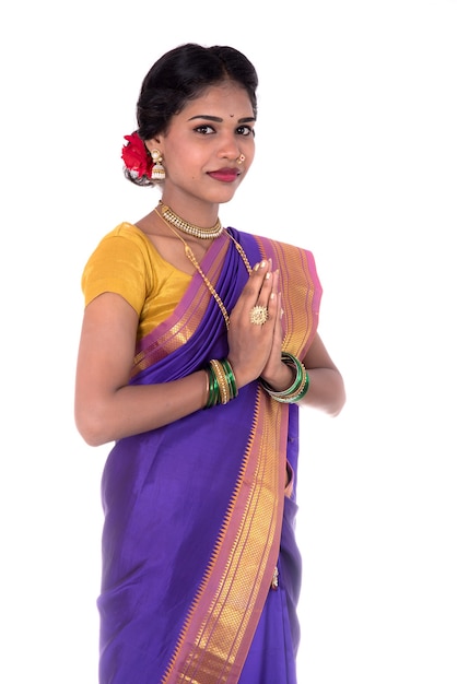 Jovem indiana com roupas tradicionais cumprimentando namaste, Bem-vindo, garota indiana com um sari tradicional com expressão de boas-vindas (convidativo)