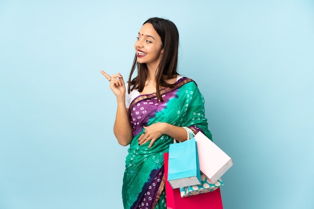 Jovem indiana com sacolas de compras tentando descobrir a solução enquanto levanta um dedo