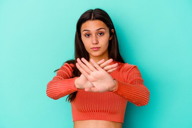 Foto jovem indiana isolada no azul fazendo um gesto de negação