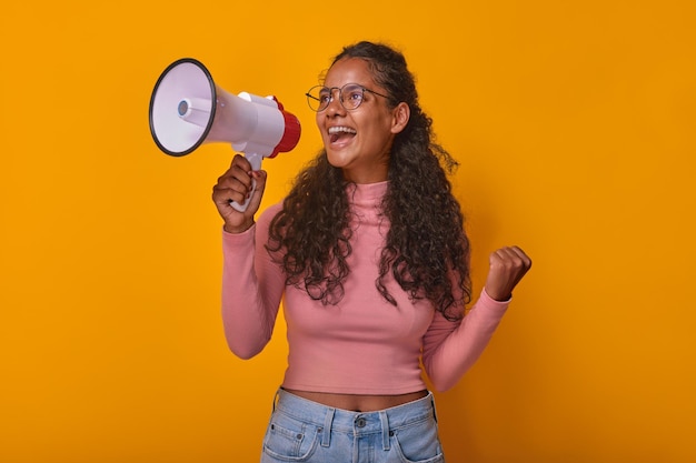 Foto jovem indiana positiva com megafone nas mãos fica em estúdio