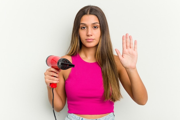 Jovem indiana segurando um secador de cabelo isolado no fundo branco