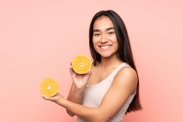 Jovem indiana segurando uma laranja