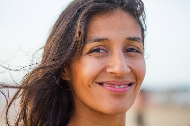 Jovem indiana sorrindo na praia