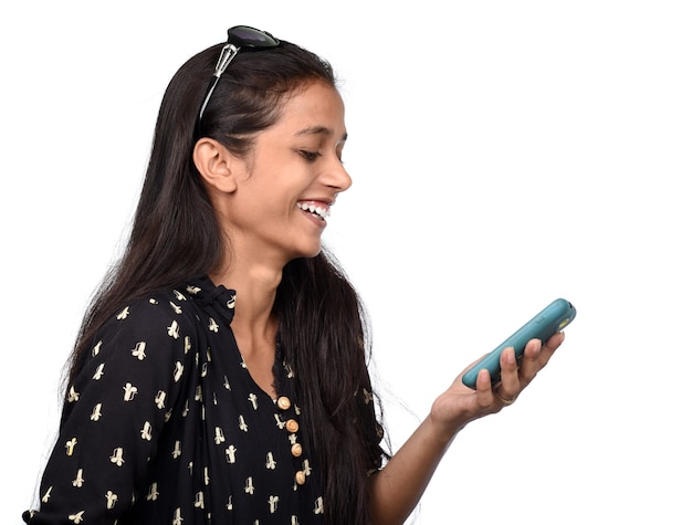 Jovem indiana usando um celular ou smartphone isolado em um fundo branco