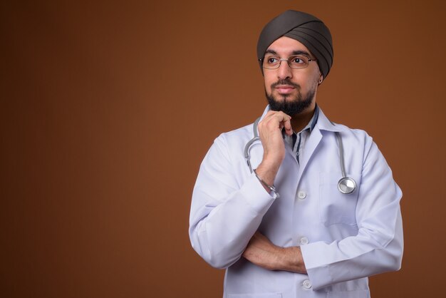 Jovem indiano barbudo Sikh, médico, usando turbante