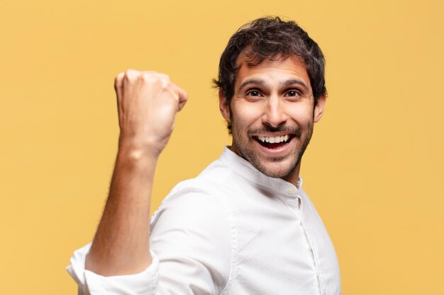 Jovem indiano bonito. celebrando um triunfo como um vencedor