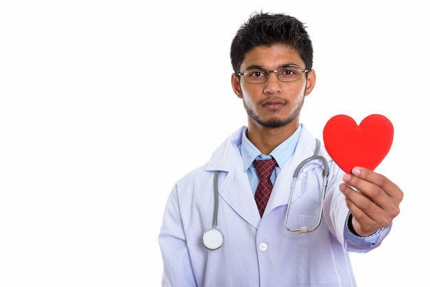 jovem indiano bonito médico segurando um coração vermelho