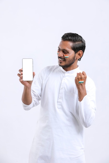 Jovem indiano comemorando o dia da independência e apresentando smartphone.