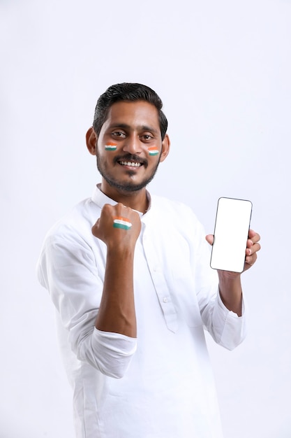 Jovem indiano comemorando o dia da independência e apresentando smartphone.