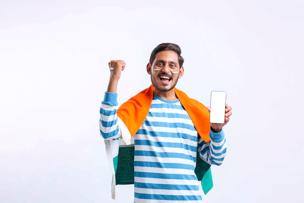 Jovem indiano comemorando o dia da independência e apresentando smartphone.