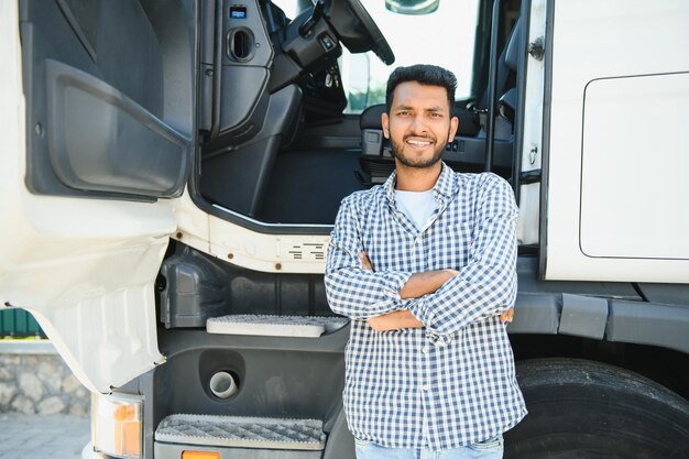 Foto jovem indiano de pé ao lado do seu camião o conceito de transporte de mercadorias