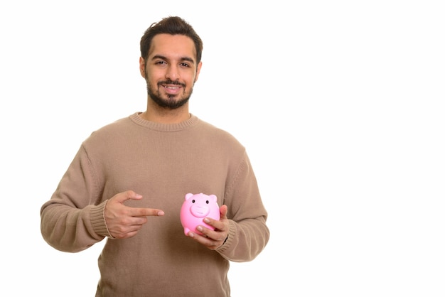 Jovem indiano feliz segurando o cofrinho e apontando