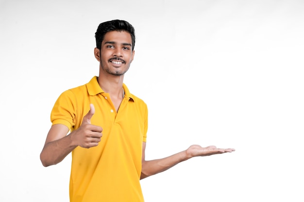 Jovem indiano mostrando expressão com a mão no fundo branco