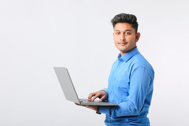 Jovem indiano usando laptop em fundo branco.