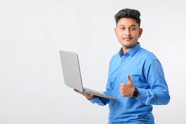 Jovem indiano usando laptop em fundo branco.