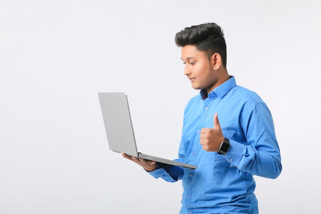 Jovem indiano usando laptop em fundo branco.