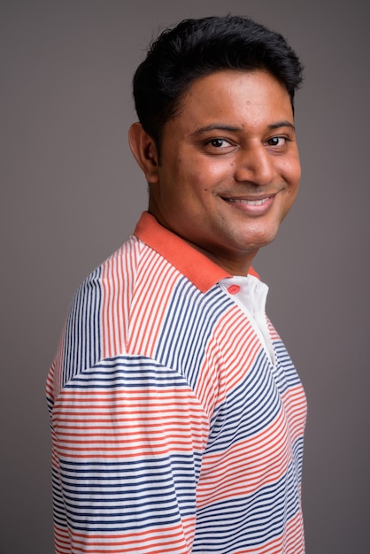 jovem indiano vestindo uma camisa pólo listrada de manga comprida