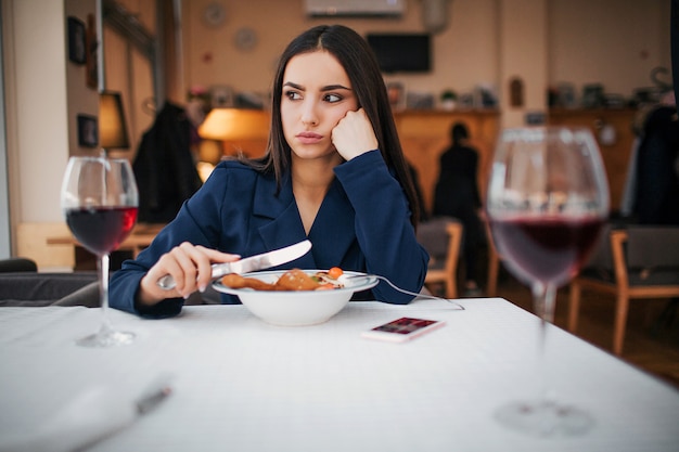 Foto jovem infeliz sentar à mesa no restaurante