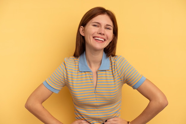 Jovem inglesa isolada em fundo amarelo feliz sorrindo e alegre